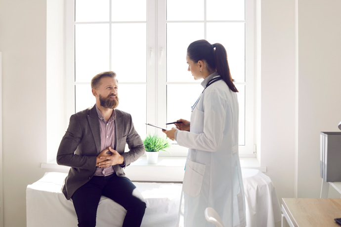 Hombre en una consulta médica por problemas de ardor estomacal.