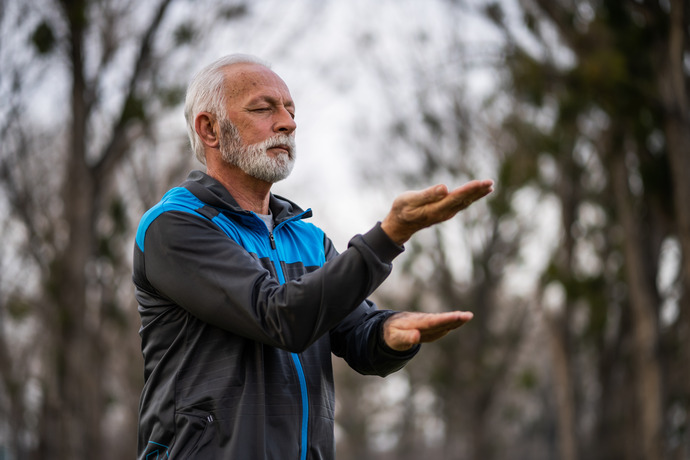 hombre mayor haciendo tai chi al aire libre