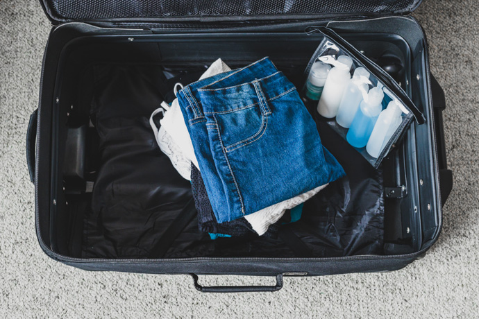 Maleta en un aeropuerto con líquidos y ropa.