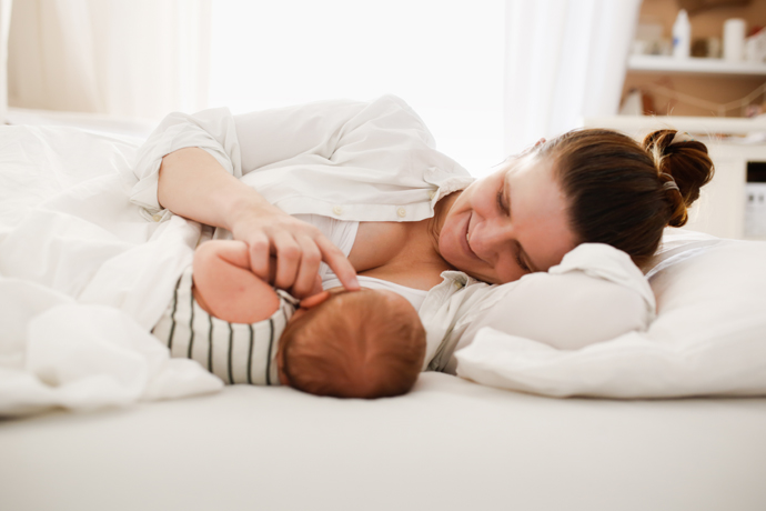 Mamá acariciando a su bebé en la cama