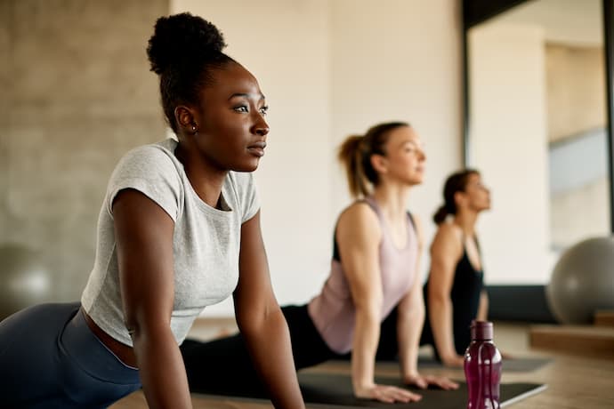 mujeres en sala de yoga haciendo ejercicio