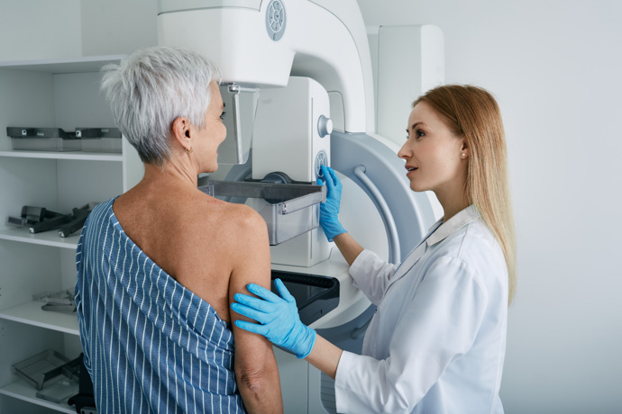 mujer con enfermera realizando una mamografia