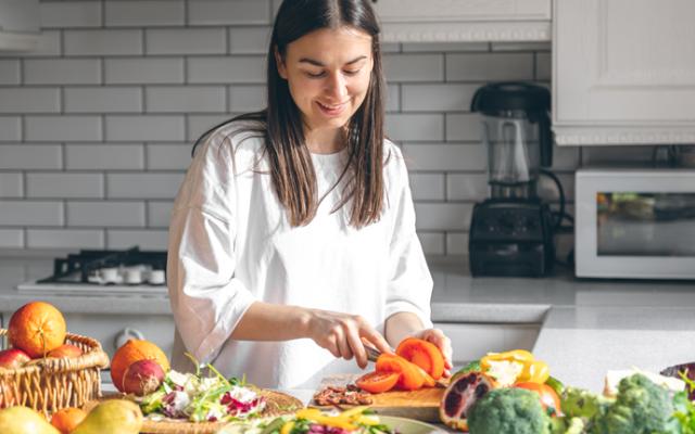 Mujer cortando vegetales en la cocina