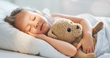 Niña durmiendo con su osito de peluche