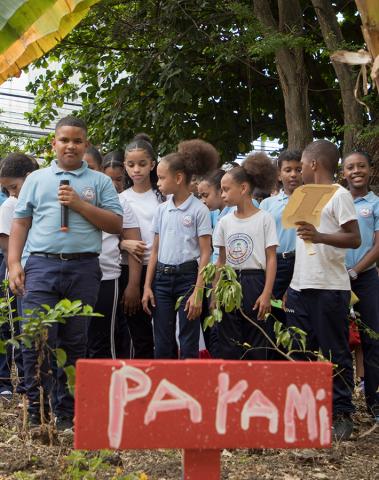 Niños de la escuela presentando los resultados de su siembra en el huerto